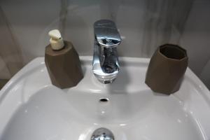 ein Waschbecken mit einem Wasserhahn und zwei Rollen Toilettenpapier darauf in der Unterkunft Blloku Studio Apartament in Tirana