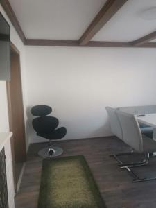 een kantoor met twee stoelen en een tafel en een tapijt bij Eisenerzer Apartmenthaus in Eisenerz
