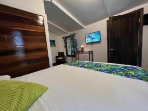 a bedroom with a white bed and a wooden door at Colinda Cabanas in Caye Caulker