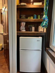 - un petit réfrigérateur dans une cuisine avec une étagère dans l'établissement Colinda Cabanas, à Caye Caulker