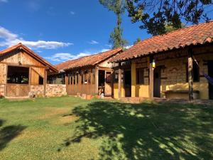 a house with a grass yard in front of it at Hotel Ráquira Silvestre Lodge in Tinjacá