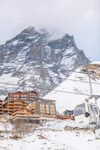 a ski lodge in front of a snow covered mountain at White Angel Hotel in Breuil-Cervinia