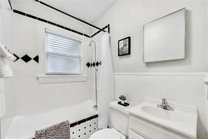 a white bathroom with a toilet and a sink at Lower-Greenville Landing Close to Everything in Dallas