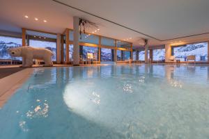 a large swimming pool with a polar bear standing in it at White Angel Hotel in Breuil-Cervinia