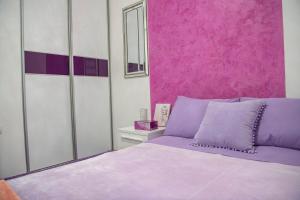 a bedroom with a purple bed and a pink wall at Apartment Queen 2 in Trebinje +14 photos