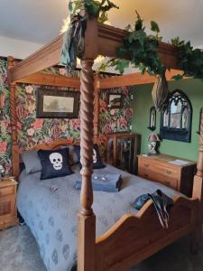 um quarto com uma cama de madeira e um dossel em Dracula Rooms em Whitby