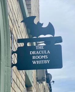 una señal en el lateral de un edificio en Dracula Rooms, en Whitby