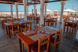 een restaurant met houten tafels en stoelen op het strand bij DM Hoteles Asia in Asia