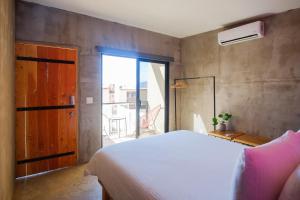 a bedroom with a white bed and a large window at Casas VV in Valle de Guadalupe