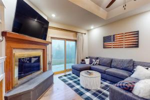 a living room with a couch and a fireplace at Solitude Village H103 in Ludlow