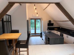 an attic kitchen with a table and a counter at Ferme du Grand Fresnoy in Molenbaix