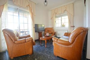 a living room with two leather chairs and a table at Dúplex da Pedra e da Auga in Meis