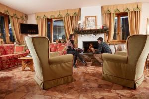 a group of people sitting in a living room with a fireplace at Meublè Cima Bianca Garni in Bormio