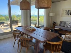 uma sala de estar com uma mesa de madeira e cadeiras em Casagrande Hotel & Beach Club em José Ignacio