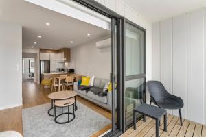 un soggiorno con divano e tavolo di Coastal Paradise - Orewa Holiday Home a Orewa