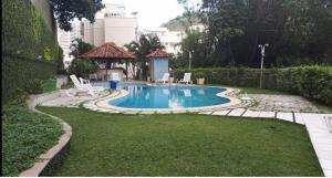 a swimming pool with two chairs and a gazebo at Apt completo com piscina e área de lazer em BOTAFOGO in Rio de Janeiro