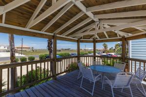 a wooden pergola with a table and chairs on a deck at Corpus Christi-Padre Island condo is walking distance to beach by Mustang Island, Sleeps Four, 2024 Traveler Award in Padre Island
