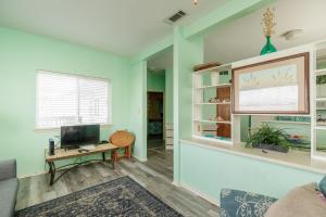 a living room with a couch and a television at Corpus Christi-Padre Island condo is walking distance to beach by Mustang Island, Sleeps Four, 2024 Traveler Award in Padre Island
