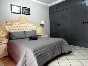 a bedroom with a large bed with a large headboard at ZUCH Accommodation at Pafuri Self Catering - Guest Apartment in Polokwane