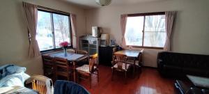 a living room with a table and a dining room at Guesthouse Aozora - Vacation STAY 07229v in Myoko