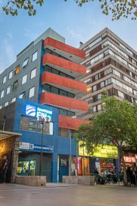 wysoki budynek przed budynkiem w obiekcie Apart Hotel Elite Las Condes w mieście Santiago