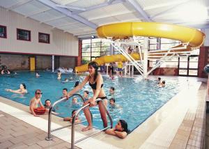 una mujer en traje de baño parada en una piscina en Ladys Mile Holiday Park, en Dawlish