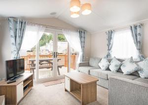 a living room with a couch and a tv at Ladys Mile Holiday Park in Dawlish