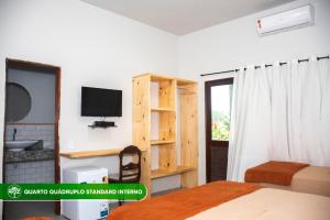 a bedroom with a bed and a tv in a room at Pousada Estação Verde in Bonito