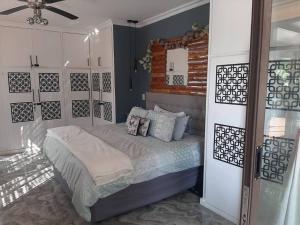 1 dormitorio con 1 cama y ventilador de techo en Tropical 4 Bedroom 3 bathroom 8 to 10 sleeper Holiday Getaway en Port Edward