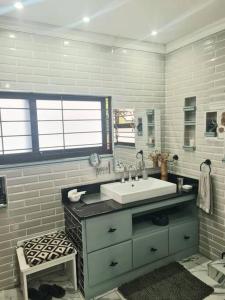 a bathroom with a white sink and a window at Tropical 4 Bedroom 3 bathroom 8 to 10 sleeper Holiday Getaway in Port Edward