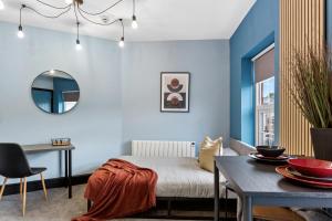 a room with a bed and a table and a mirror at Cozy and Quirky Central Derby Apartments in Derby