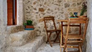 un tavolo e una sedia accanto a un muro di pietra di Alle Vecchie Querce a Fontecchio