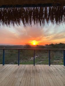 a wooden deck with a sunset in the background at Casa Sol in Clil