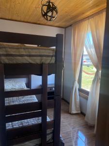a bunk bed in a room with a window at Cabañas Santa Cruz, Ubicada a 10 min de la plaza, Piscina , Viñas, Ruta del Vino y mas in Santa Cruz
