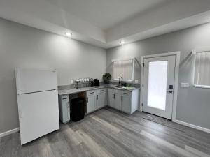 a kitchen with white cabinets and a white refrigerator at Beach Road Hale in Keaau