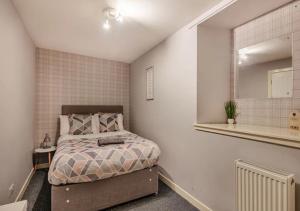 Dormitorio pequeño con cama y espejo en Townhouse Apartment 3 Bedroom High St Montrose en Montrose