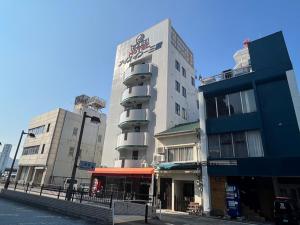 a building on a street with two tall buildings at Hotel Bayside Mihara - Vacation STAY 02319v in Mihara