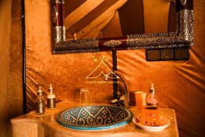a bathroom with a sink and a mirror on a counter at Sahara Desert Camping - Luxury Desert Camp Merzouga in Erfoud +113 photos
