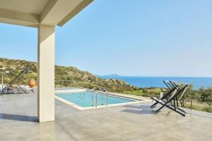 a swimming pool with a view of the ocean at Ligres Villa in Agia Paraskevi