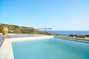 a swimming pool with the ocean in the background at Ligres Villa in Agia Paraskevi
