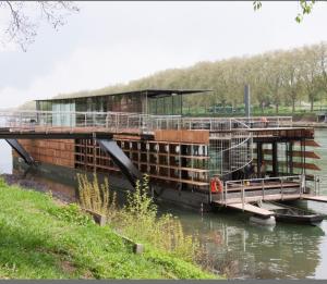 um grande barco está ancorado num rio em Appartement au bord de seine em Épinay-sur-Seine