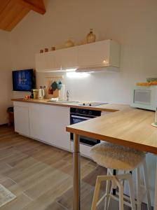 a kitchen with white cabinets and a wooden table at La Gourgasse Vieille in Béziers