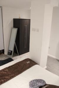 a room with a bed and a refrigerator in it at Amazing Luxury One Bedroom Apartment in the heart of Preston in Preston