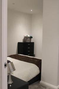 a bedroom with a bed and a black dresser at Amazing Luxury One Bedroom Apartment in the heart of Preston in Preston