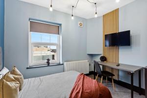 a bedroom with a bed and a desk and a window at Cozy and Quirky Central Derby Apartments in Derby