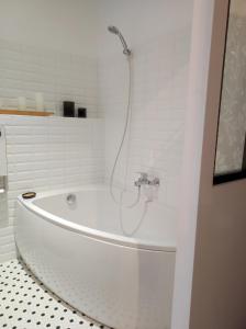 a white bath tub with a shower in a bathroom at La Gourgasse Vieille in Béziers