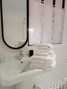 a white bathroom with a sink and a mirror at La Gourgasse Vieille in Béziers