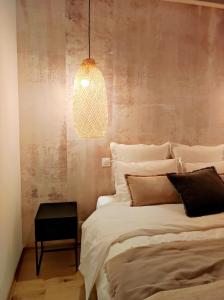 een slaapkamer met een bed en een hanglamp bij La Gourgasse Vieille in Béziers