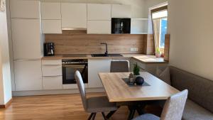 a kitchen with a wooden table and chairs in a room at Haus Dorfblick in Filzmoos