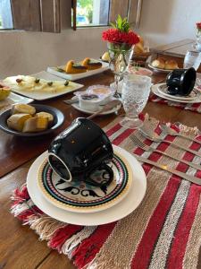 a table with plates of food and a toaster on it at Pousada Anacã in Arraial d'Ajuda